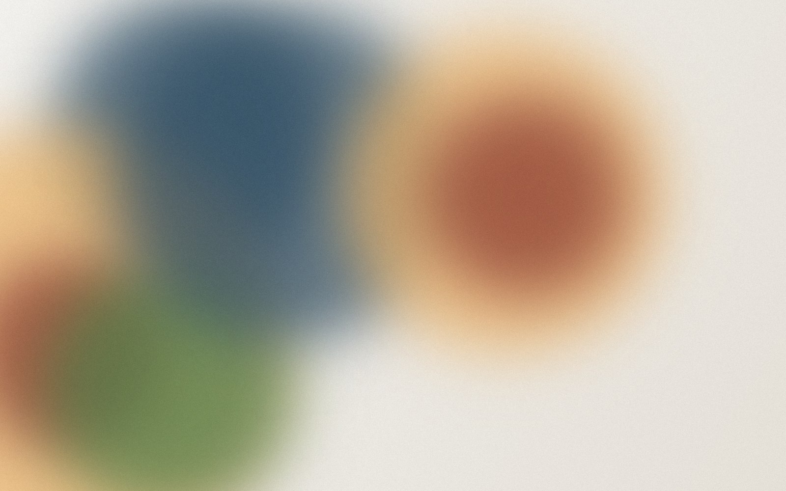 Four blurry coloured circles on a white background.